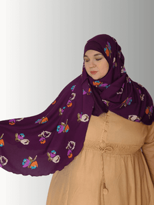 "A rich purple hijab featuring a chiffon overlay with multicolored floral patterns, styled with a beige outfit. Includes front and back views to highlight the flowy design and full coverage."

