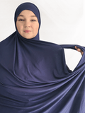 Deep navy blue double loop hijab with a built-in undercap, shown in natural light highlighting its rich color and soft, thick texture.
