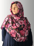 A luxurious Italian silk couture hijab featuring a bold pink floral print on a black background, elegantly draped."
