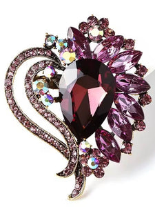 Elegant gold and amethyst brooch with a deep purple teardrop gemstone, floral rhinestone details, and sparkling accents.