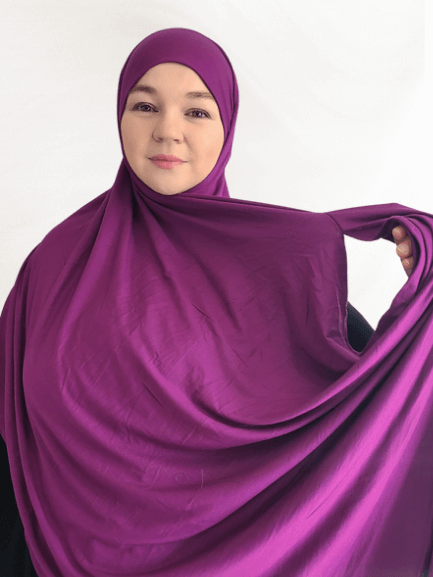 Berry-toned double loop instant hijab with attached undercap, styled in soft layers showing its bold orchid hue and thicker jersey texture.