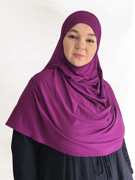 woman modeling a deep berry-purple Instant Jersey Shawl with a matching undercap, showcasing the soft drape and structured feel of the slightly thicker fabric.