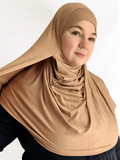 A creamy golden beige jersey double loop hijab with attached undercap, displayed with soft, flattering lighting to show its smooth drape and neutral tone.