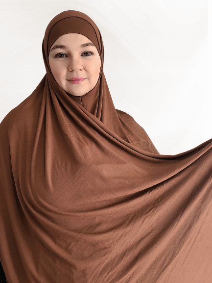 Rich caramel brown instant jersey hijab shawl with a slightly thicker, soft fabric and matching undercap displayed in warm lighting.