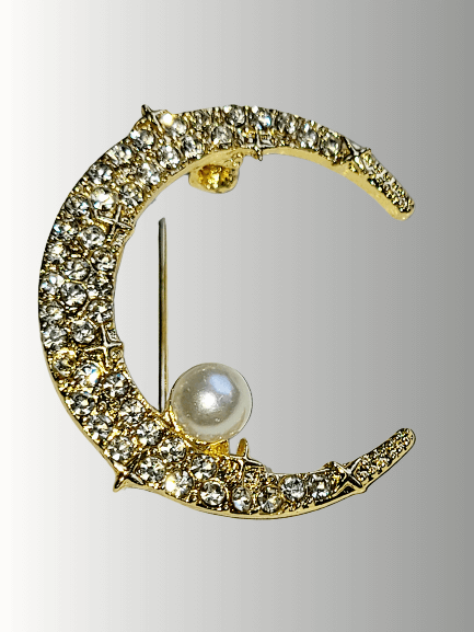 Gold crescent moon brooch with rhinestones and a pearl accent.