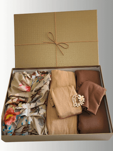 "Golden Garden Gift Set featuring a floral satin Luxe Harmony veil, two instant jersey shawls in golden beige and toffee glow shades, a decorative brooch pin, all beautifully arranged in a luxury gold textured gift box with ribbon."
