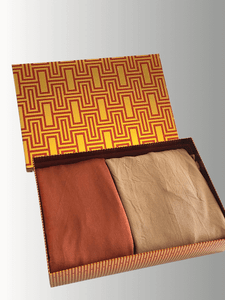 Desert Bloom Gift Set with two double-loop instant jersey shawls in terracotta and golden beige tones, neatly folded inside a warm-toned patterned gift box with a golden and red geometric lid design