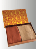 Desert Bloom Gift Set with two double-loop instant jersey shawls in terracotta and golden beige tones, neatly folded inside a warm-toned patterned gift box with a golden and red geometric lid design