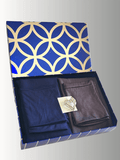 Navy blue and charcoal grey hijabs folded in a luxe blue and gold patterned gift box, adorned with a pearl heart brooch.

