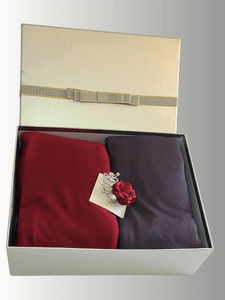 Crimson Twilight Gift Set featuring instant jersey shawls in pomegranate red and charcoal, paired with a decorative floral brooch, elegantly packed in a white gift box with gold ribbon detailing.
